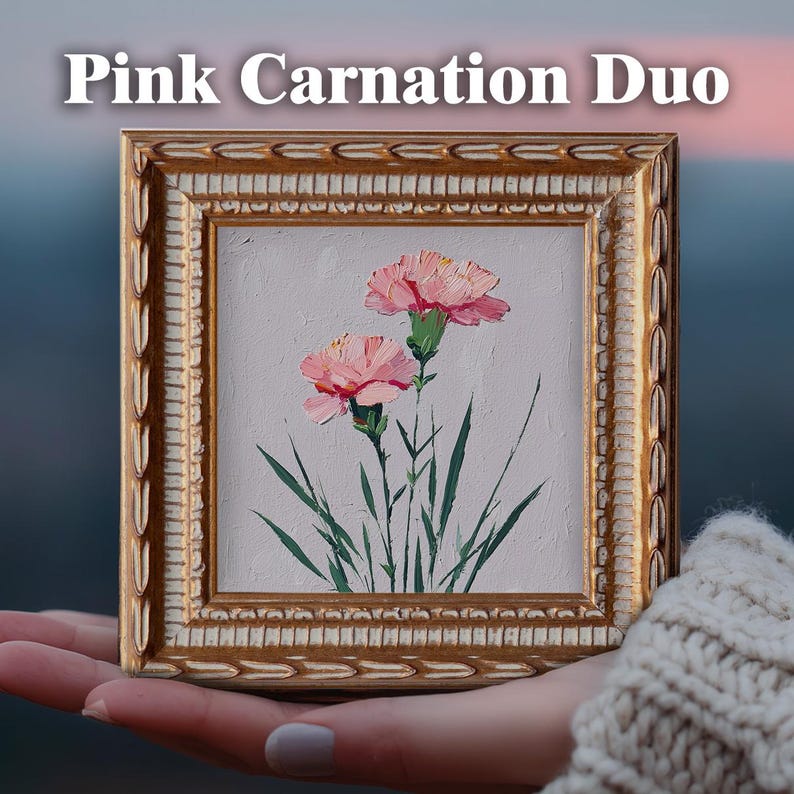 May include: A square oil painting titled Pink Carnation Duo featuring two pink carnations with green stems and leaves on a light gray background, encased in an ornate, textured gold frame with a decorative leaf-patterned border.
