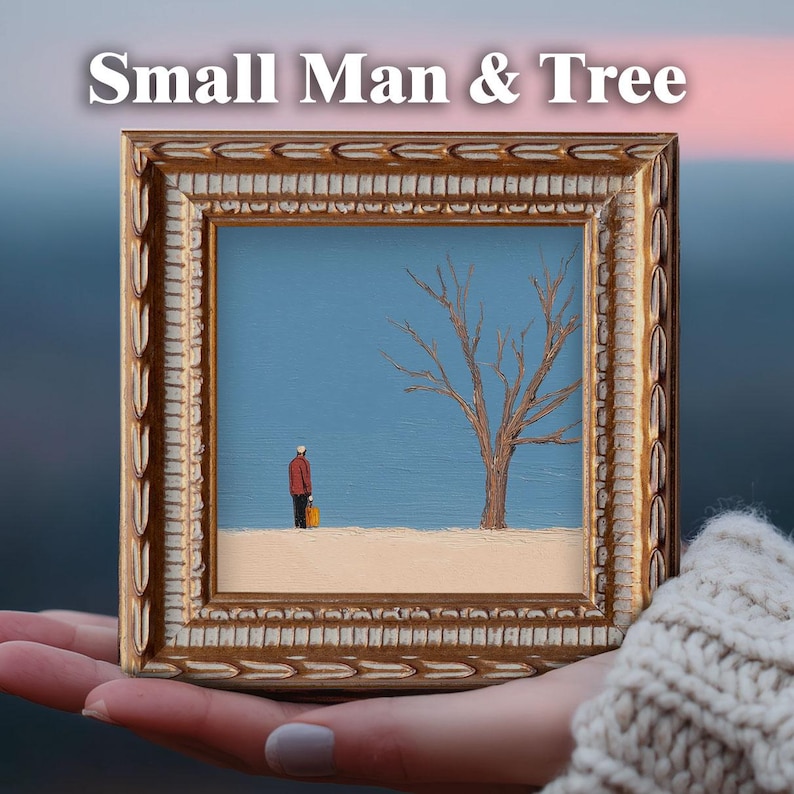 May include: A framed painting titled "Small Man & Tree" depicts a small figure in a red jacket and a bare tree against a blue sky. The painting is in a gold ornate frame, held in a person's hand.