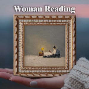 May include: A framed painting with the text "Woman Reading" at the top. The painting depicts a person in a white dress reading under a yellow lamp. The frame is gold with ornate detailing.