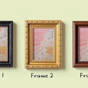 May include: Three framed art prints. Each features a beach scene with figures. The frames are black, gold, and brown. The artwork has a pink and yellow sky with white waves. The text "Frame 1", "Frame 2", and "Frame 3" is below each frame.