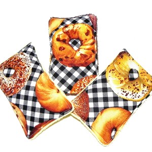 May include: Three black and white checked kitchen scrubbers with a variety of bagel designs. The scrubbers are made of a soft, absorbent material and are perfect for cleaning dishes and countertops.
