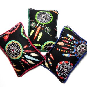 May include: Three black fabric pillows with colorful dreamcatcher designs. The pillows have different colored trim around the edges.