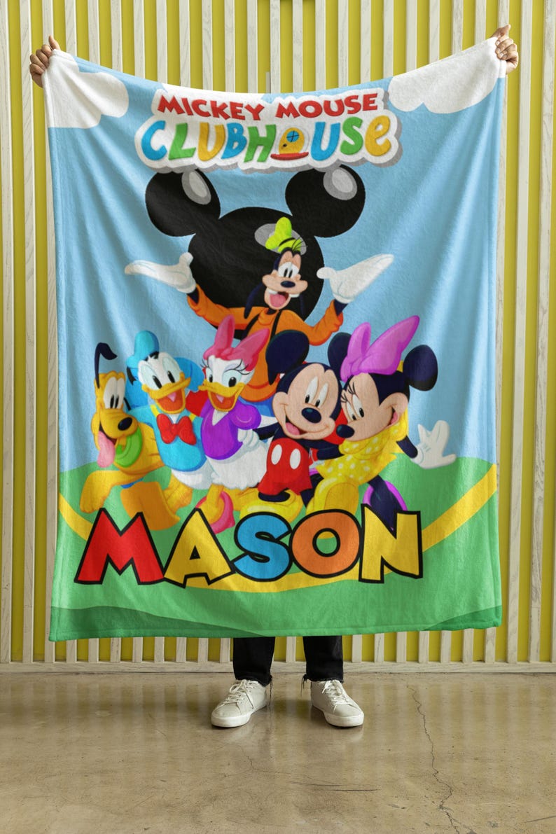May include: A light blue fleece blanket featuring the Mickey Mouse Clubhouse logo at the top and a group illustration of Goofy, Pluto, Donald Duck, Daisy Duck, Mickey Mouse, and Minnie Mouse. The name MASON is printed in large, colorful letters.