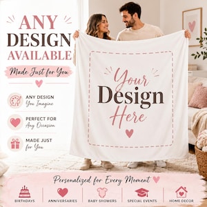 May include: A white rectangular throw blanket featuring a central dashed-line border and the text "Your Design Here" in dark gray and pink script. The blanket includes small pink heart icons and is displayed as a customizable product template.