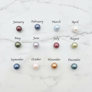 Puede incluir: Doce perlas de colores, cada una representando un mes del a&ntilde;o, est&aacute;n dispuestas en una cuadr&iacute;cula. Los meses est&aacute;n etiquetados de enero a diciembre. Las perlas var&iacute;an en color, incluyendo tonos de rojo, azul, verde y dorado.