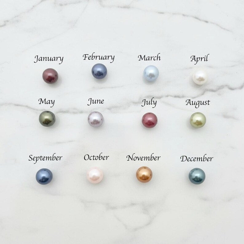 Puede incluir: Doce perlas de colores, cada una representando un mes del a&ntilde;o, est&aacute;n dispuestas en una cuadr&iacute;cula. Los meses est&aacute;n etiquetados de enero a diciembre. Las perlas var&iacute;an en color, incluyendo tonos de rojo, azul, verde y dorado.
