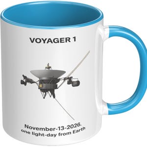 May include: White ceramic mug with a blue interior and handle. The mug features an illustration of the Voyager 1 spacecraft and the text "VOYAGER 1". Below the spacecraft is the text "November-13-2026. one light-day from Earth."