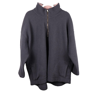 May include: A dark gray fleece pullover with a high collar and a gold-colored zipper. The inside collar is a light pink color. The pullover has a relaxed fit and side pockets. This cozy fleece is perfect for cooler weather.