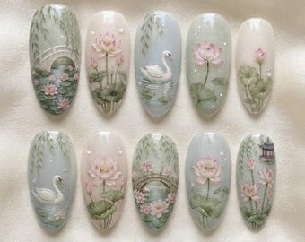 Può includere: Un set di dieci unghie finte ovali con dettagliati disegni dipinti a mano raffiguranti cigni bianchi, fiori di loto rosa, ninfee verdi, ponti ad arco e strutture tradizionali su sfondi color pastello con una finitura lucida.