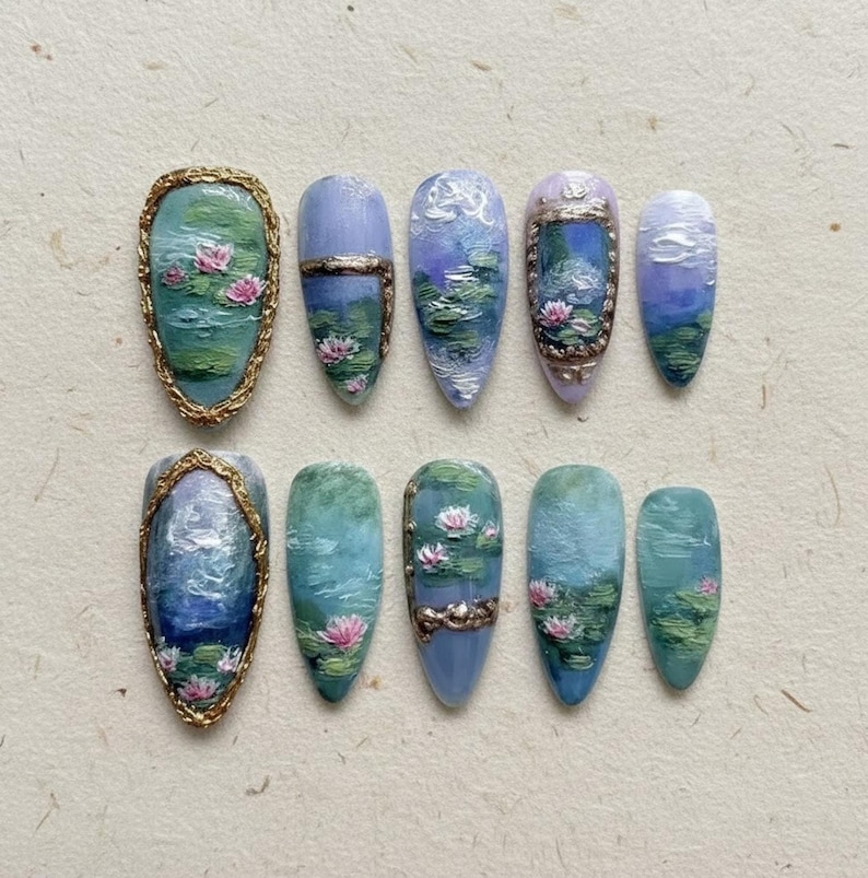 以下が含まれることがあります： アーモンド型のつけ爪10本セット。水連のミニチュア絵画が施されています。デザインは青、緑、ピンクの色合いで、金と銀のアクセントがあります。ネイルは穏やかで芸術的な美しさを醸し出しています。