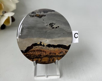 Plato de jaspe con paisaje en tonos rosa, rojo y beige. Arte en piedra sobre soporte.