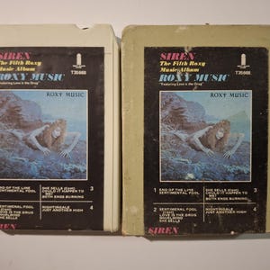 May include: Two vintage Roxy Music "Siren" music album 8-track tapes. The album art features a woman with long hair in a blue and gray landscape. The album title and track list are visible.