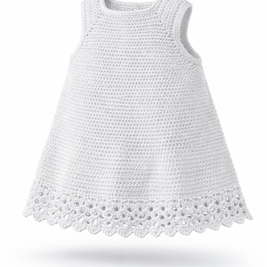 May include: A sleeveless white dress crafted with a dense crochet stitch pattern throughout the bodice and skirt. The garment features a round neckline and a decorative, scalloped crochet lace border along the bottom hemline of the dress.