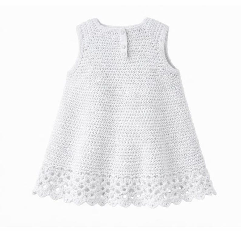May include: A sleeveless white dress featuring a dense crochet knit pattern throughout the bodice and a decorative, openwork scalloped lace border along the hem. The garment includes a vertical placket at the upper back with three small buttons.
