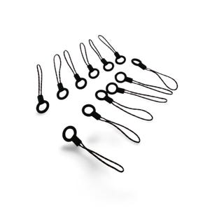 May include: A collection of black phone charms with a loop and a cord. The charms are scattered across a white background. The loop is round and the cord is thin and textured.