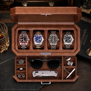 May include: A brown leather valet box featuring four watch slots containing silver-tone wristwatches, a pair of black sunglasses, a folding pocket knife, three rings, and two small metal components organized in dedicated compartments.