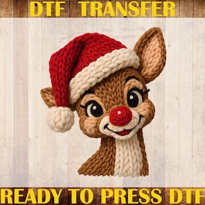 May include: A DTF transfer featuring a cartoon reindeer with a red knit hat and a red nose. The reindeer has a smiling expression and is made to look like it is knitted. The text "DTF TRANSFER", "CUSTOM PRINT", and "READY TO PRESS DTF" are visible.