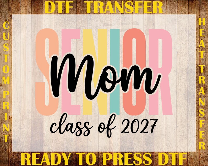 May include: A DTF heat transfer design featuring the word SENIOR in large, pastel-colored block letters behind the black script text Mom and the black text class of 2027. The border includes the yellow text DTF TRANSFER, CUSTOM PRINT, and READY TO PRESS DTF.