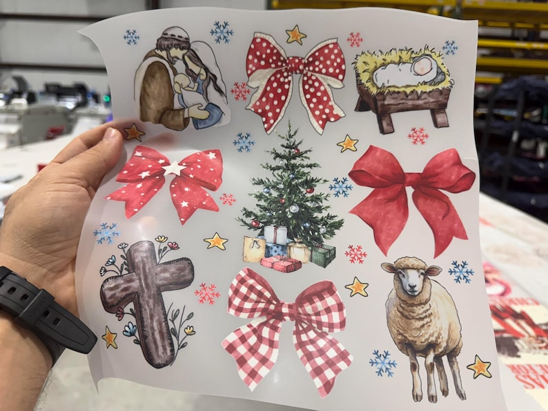 May include: A sheet of Christmas-themed stickers with watercolour illustrations. Designs include a nativity scene, bows, a Christmas tree with presents, a cross, a sheep, snowflakes, and stars. The stickers are in various colours, including red, green, and brown.