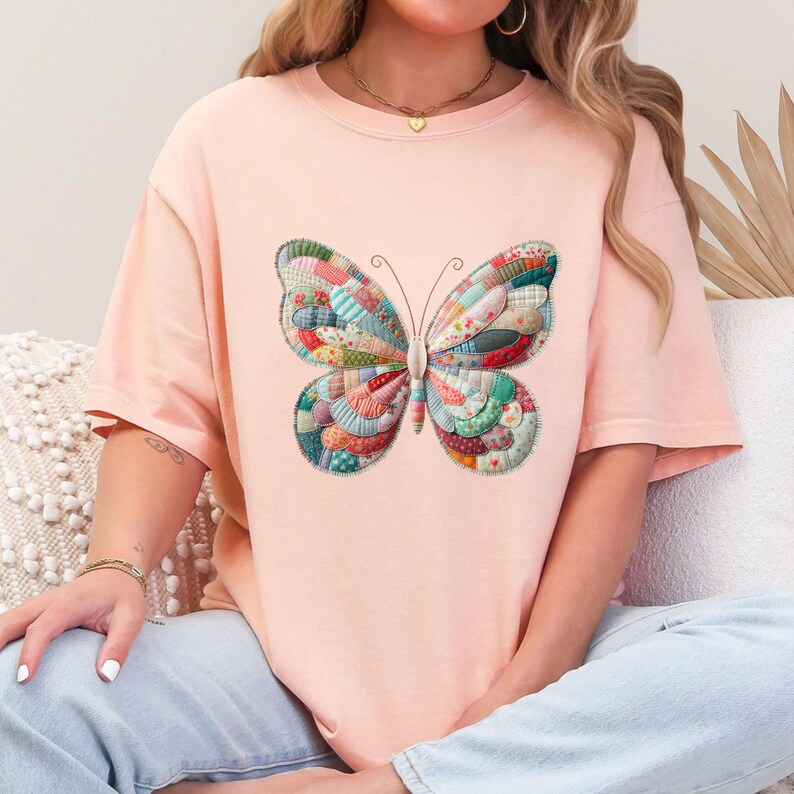 Puede incluir: Camiseta rosa claro con un dise&ntilde;o de mariposa colorida. La mariposa presenta un patr&oacute;n de retazos en varios colores, incluyendo azul, verde, rojo y amarillo. La camiseta es de estilo casual y c&oacute;modo.
