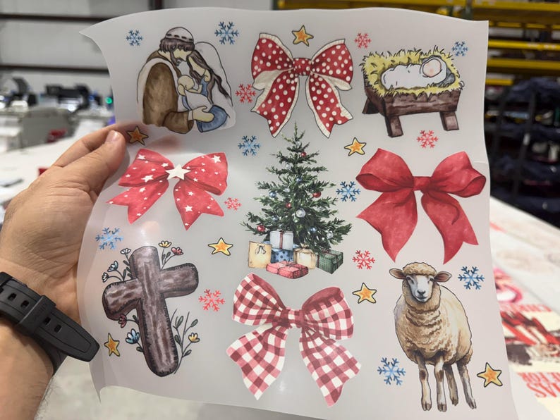 May include: A sheet of Christmas-themed stickers featuring watercolor illustrations. The designs include a Christmas tree, bows, a nativity scene, a cross, a sheep, snowflakes, and stars. The stickers are in various colors, including red, green, and brown.