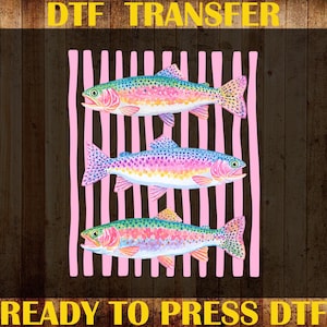May include: DTF transfer design featuring three colorful rainbow trout on a pink striped background. The image includes the text "DTF TRANSFER", "CUSTOM PRINT", "HEAT TRANSFER", and "READY TO PRESS DTF" in yellow.