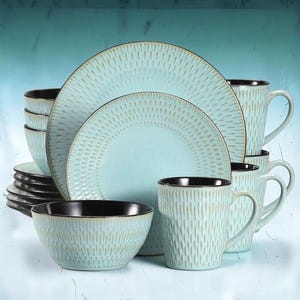 Puede incluir: Un juego de vajilla que incluye platos, cuencos y tazas de color azul claro con un patrón texturizado de rayas verticales en color beige. Cada pieza tiene un borde interior y una base de color marrón oscuro, manteniendo un diseño uniforme.