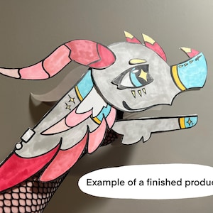 May include: A colorful, hand-drawn dragon head with pink, red, blue, and yellow accents. The dragon has large eyes, horns, and a long snout. The text "Example of a finished product!" is in a white oval.