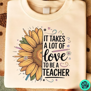May include: A cream-coloured sweatshirt with a sunflower design and the text "IT TAKES A LOT OF LOVE TO BE A TEACHER." The sunflower is yellow and orange with green leaves and pencils. The design includes hearts and stars.