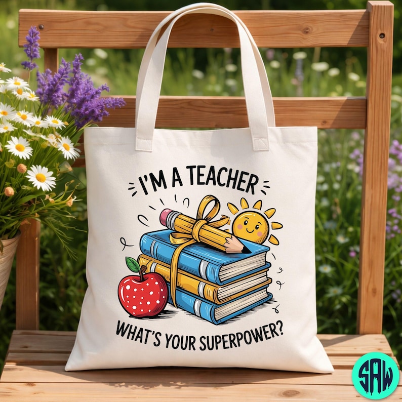 May include: Off-white tote bag printed with the words "I'M A TEACHER WHAT'S YOUR SUPERPOWER?" and a graphic of books, a pencil, a sun, and an apple. The bag has two handles and is made of a durable fabric.