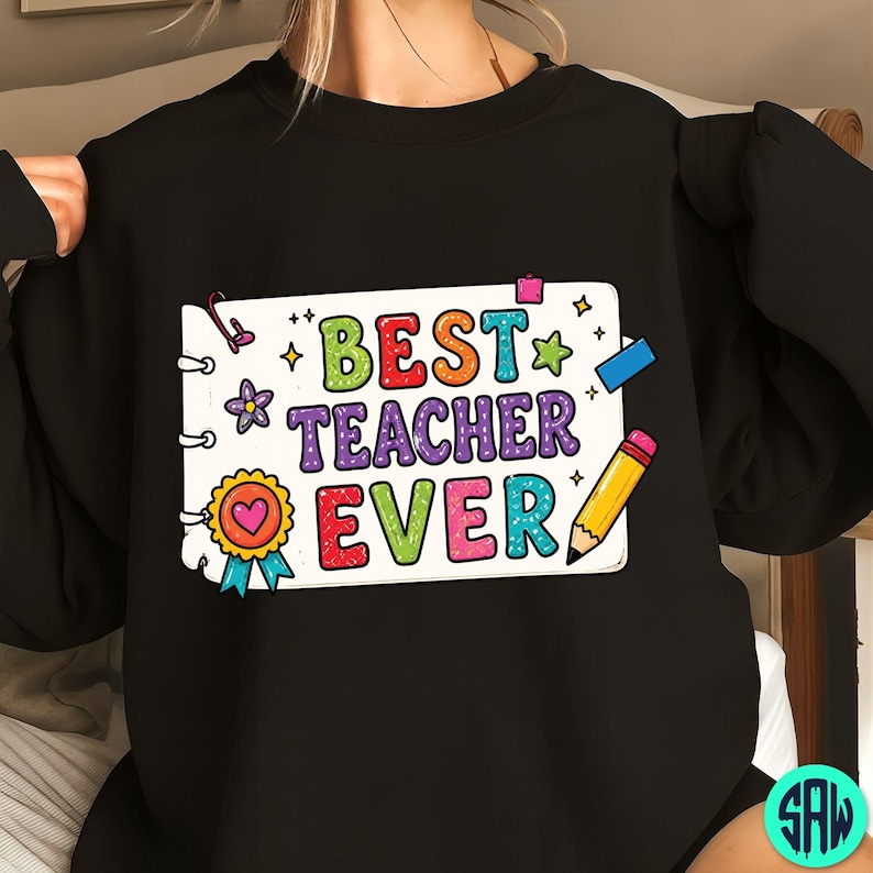 May include: Black sweatshirt featuring the text "BEST TEACHER EVER" in a colourful design. The graphic includes a notepad, pencil, stars, and a heart-shaped award ribbon. The text is in various colours, including green, orange, purple, and red.