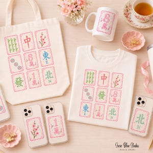 A collection of off-white merchandise featuring Mahjong tile graphics with pink borders. Items include a canvas tote bag, a t-shirt, a ceramic mug, a tumbler with a straw, and four clear phone cases, each displaying various Mahjong tile symbols.