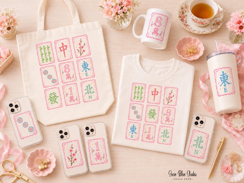 A collection of off-white merchandise featuring Mahjong tile graphics with pink borders. Items include a canvas tote bag, a t-shirt, a ceramic mug, a tumbler with a straw, and four clear phone cases, each displaying various Mahjong tile symbols.