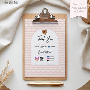 Pu&ograve; includere: Un portablocco in legno con una nota "Grazie" stampata. La nota presenta uno sfondo a motivi ondulati rosa e bianco, una grafica a biscotto e icone di social media. Una penna dorata &egrave; posizionata sotto.