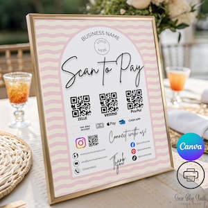 May include: A framed sign with a gold border, featuring the text "Scan to Pay" in elegant script. It includes QR codes for Zelle, Venmo, and PayPal, along with social media icons and contact information. The background has a pink and white wavy pattern.