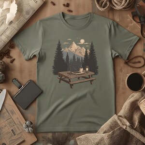 T-shirt med scen från Nomadic Workspace Camp Desk | Distansarbete, Lykta, Tallar, Comfort Colors® Moss