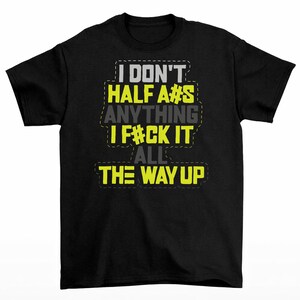 May include: Black t-shirt with the text "I DON'T HALF A#S ANYTHING I F#CK IT ALL THE WAY UP" in white, yellow, and gray block letters. The text has a stitched outline effect.