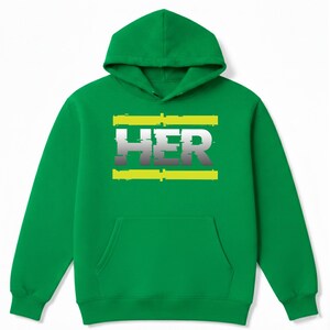 May include: Green hooded sweatshirt with a front pocket and a drawstring hood. The word "HER" is printed across the chest in white and gray, framed by two yellow horizontal lines.
