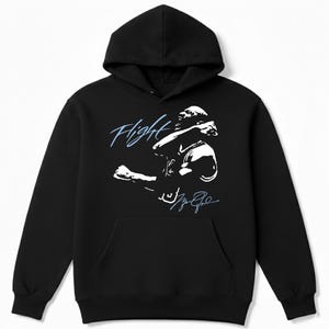 May include: Black hooded sweatshirt with a front pocket and a white graphic of a basketball player in action. The word "Flight" is written in light blue script above the image, with a signature below.
