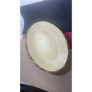 Puede incluir: Plato ovalado para servir con interior color crema y borde decorativo estilo bambú. El borde es de color marrón cálido y el interior tiene un sutil patrón arremolinado. El plato está diseñado para servir alimentos.