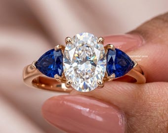 Anillo de compromiso con diamante ovalado cultivado en laboratorio de 2,50 ct / Zafiro azul natural engastado en talla trillón en los laterales /