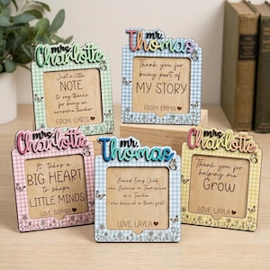 May include: Five wooden picture frames with personalized messages for teachers. Each frame has a gingham pattern, floral accents, and butterfly details. The frames feature names like "Charlotte" and "Thomas" with messages of gratitude.