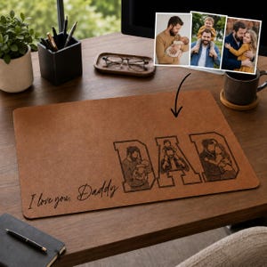 May include: A brown leather desk mat with the word "DAD" etched into it, with family photos inside each letter. The phrase "I love you, Daddy" is written in cursive. The mat is on a wooden desk with office supplies.