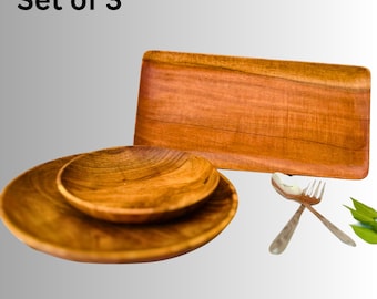 May include: A set of three wooden serving pieces. The set includes two round plates, a rectangular tray, and a spoon and fork. The plates and tray are made of a warm-toned wood.