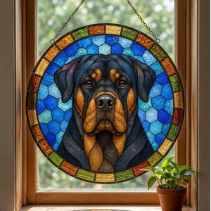Handmade stained glass Rottweiler suncatcher hanging in a wooden window with blue mosaic glass