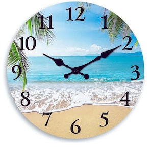 May include: Circular wall clock depicting a beach scene with a blue ocean, sandy shore, and palm trees. The clock face has black numerals and hands. The clock's design evokes a tropical holiday theme.