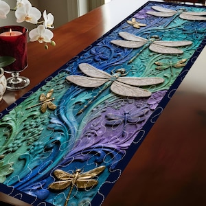 May include: A decorative table runner featuring a 3D dragonfly design. The runner has a dark blue border and a gradient of colors, including green, blue, and purple. Several dragonflies are gold and silver, with detailed wings.