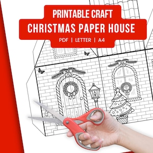 Peut inclure: Un modèle de maison de Noël en papier imprimable en noir et blanc avec une bannière rouge indiquant "PRINTABLE CRAFT CHRISTMAS PAPER HOUSE". Le design comprend une porte avec une couronne, des fenêtres et un sapin de Noël. Une paire de ciseaux à poignée rouge est au premier plan.