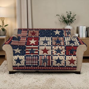 May include: A sofa cover with a patchwork design featuring red, white, and blue stars and stripes. The cover is draped over a beige sofa, creating a patriotic theme. The cover's design includes various star patterns and American flag motifs.