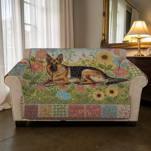 May include: A floral patterned sofa cover featuring a German Shepherd dog. The cover has a patchwork design along the bottom edge with various floral patterns, including sunflowers and other colorful blooms. The dog is lying down on the cover.